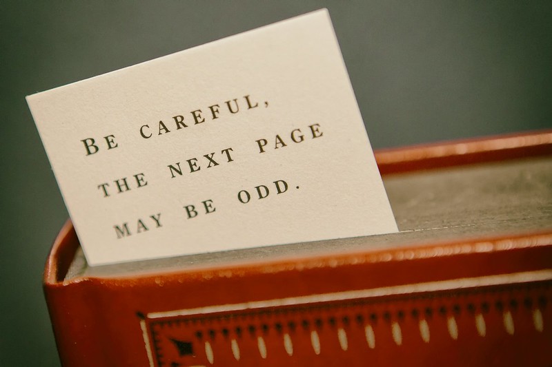 A bookmark with the text on it, jocularly warning the reader, “The next page might be odd”